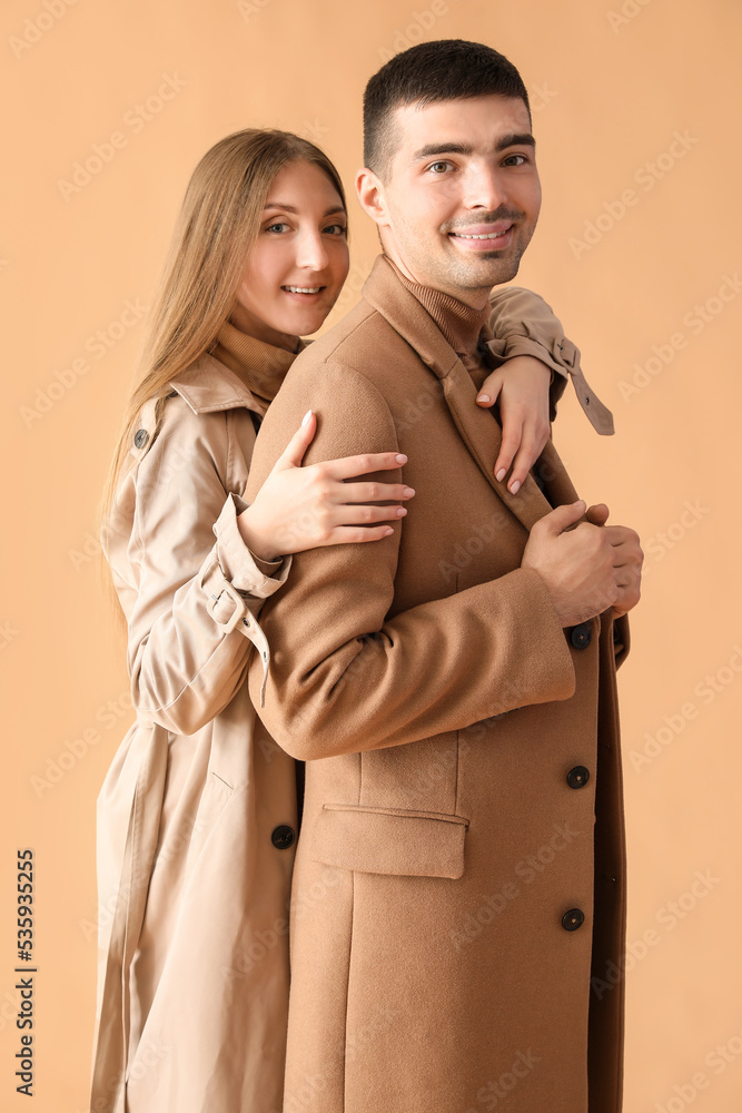Fashionable young couple in autumn clothes on beige background Fashionable young couple in autumn clothes on beige background