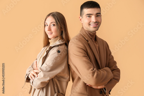 Fashionable young couple in autumn clothes on beige background © Pixel-Shot