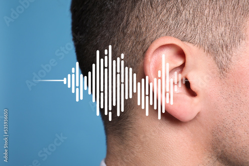 Hearing loss concept. Man and sound waves illustration on light blue background, closeup photo
