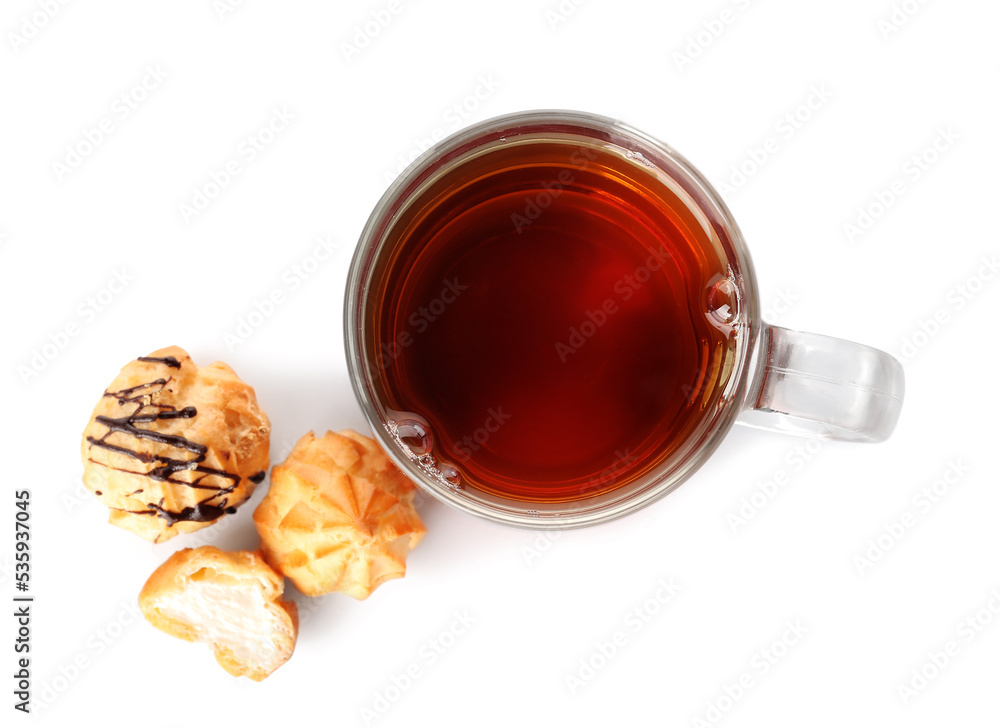 Cup of tea and tasty eclairs on white background