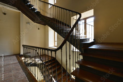 Landing on the stairs of a vintage house with solid wood steps and metal balustrade