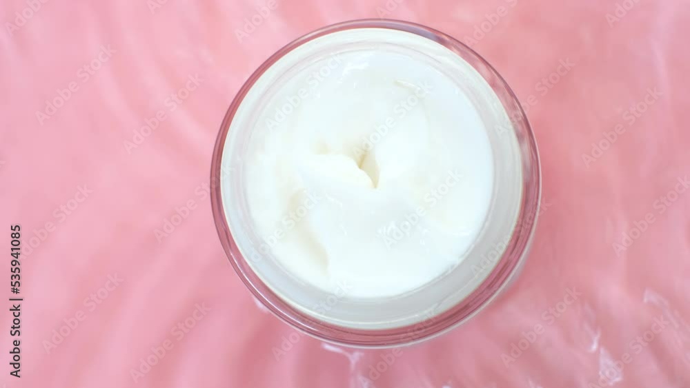 Jar cream underwater on pink background close-up top view. Jar cream underwater on pink background close-up top view.