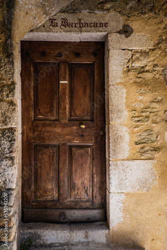 Old wooden door of a medieval stone house in the village of Saint Montan in Ardeche (South of France)