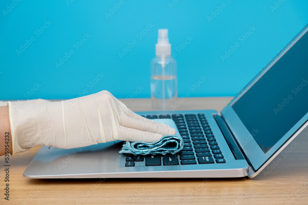 Woman hand cleaning laptop with wipes Woman hand cleaning laptop with wipes