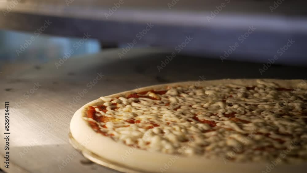 Pizza baking in rotating commercial pizza oven, slow motion close up 4K Pizza baking in rotating commercial pizza oven, slow motion close up 4K