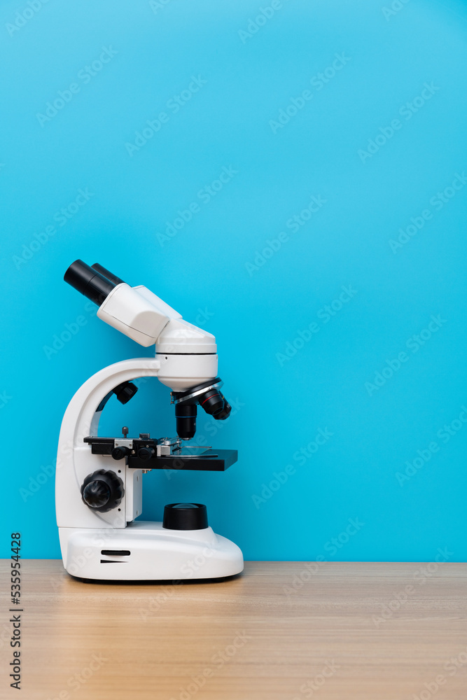 Close up of microscope on wooden table Close up of microscope on wooden table