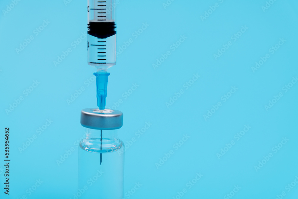 Syringe inserted into vaccine bottle Syringe inserted into vaccine bottle