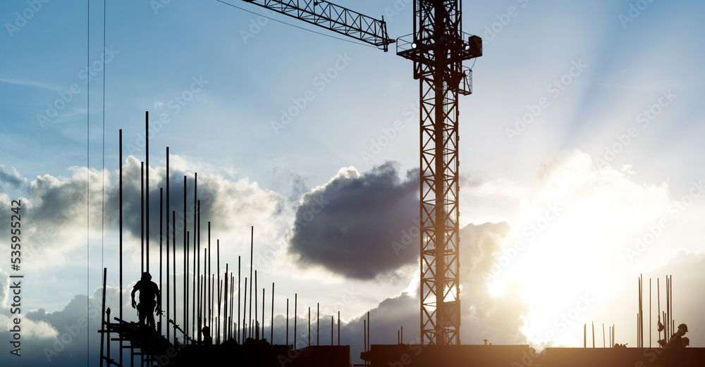 Building construction site with crane under cloudy sky