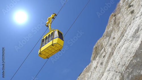 Yellow Cableway Cabin against blue sky and white chalk cliff. Rosh Hanikra, Mediterranean, Israel