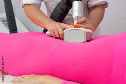 Crop masseuse doing vacuum massage to female customer