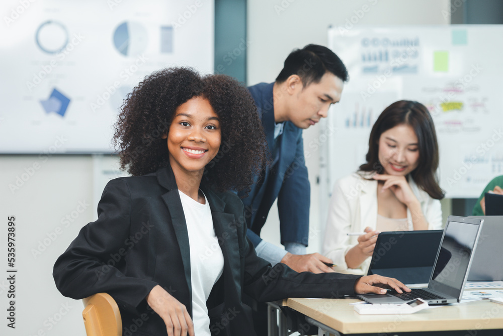 Close-up shot of an American woman attending a conference room at a startup, she is an employee of the International Marketing Department meeting with management and employees to plan a sales boost. Close-up shot of an American woman attending a conference room at a startup, she is an employee of the International Marketing Department meeting with management and employees to plan a sales boost.
