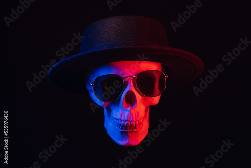 Wallpaper Mural human skull wearing sunglasses and a hat with colored neon light on a dark background Torontodigital.ca