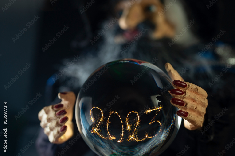 2023 written with sparklers and sparks, inside a crystal ball. - obrazy, fototapety, plakaty 
