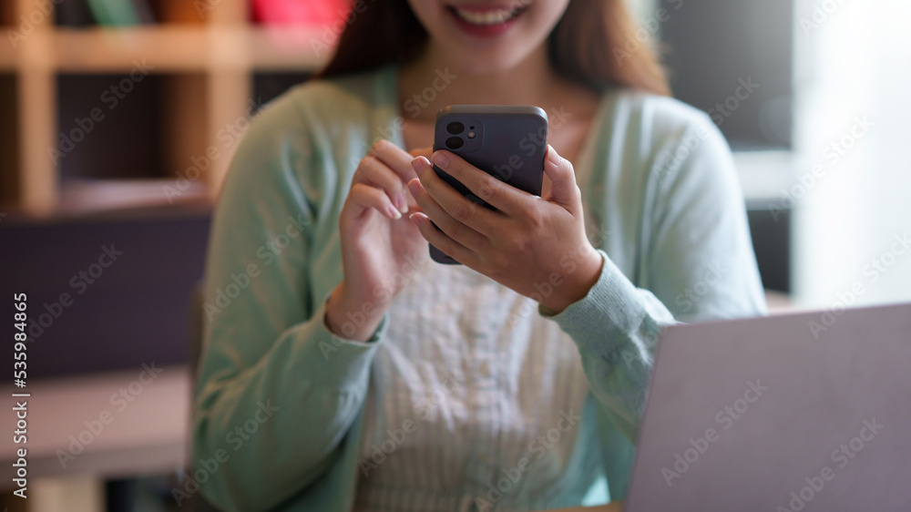 Close-up of a woman using a smartphone to work with customers via LINE messaging applications make financial transactions or play social media. Close-up of a woman using a smartphone to work with customers via LINE messaging applications make financial transactions or play social media.