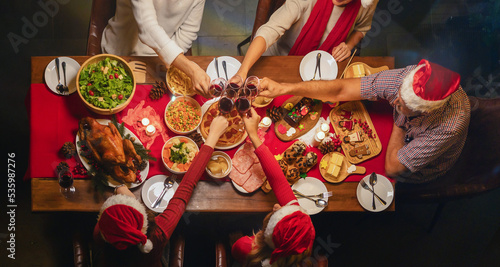 A group of multi ethnic.Portrait of Caucasian and African American black family have a celebration dinner in party with wine, champagne on Merry Christmas Eve Xmas on holiday at home. People lifestyle
