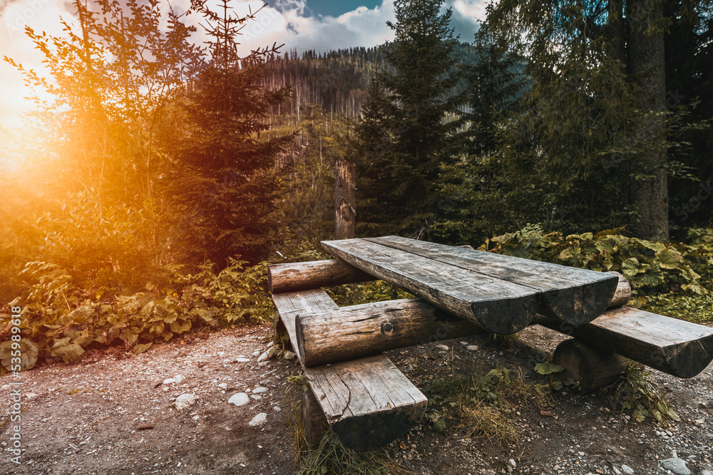 Empty outdoor wooden furniture in the Tatra National Park. Concept of having a picnic outdoors with a beautiful mountain view.