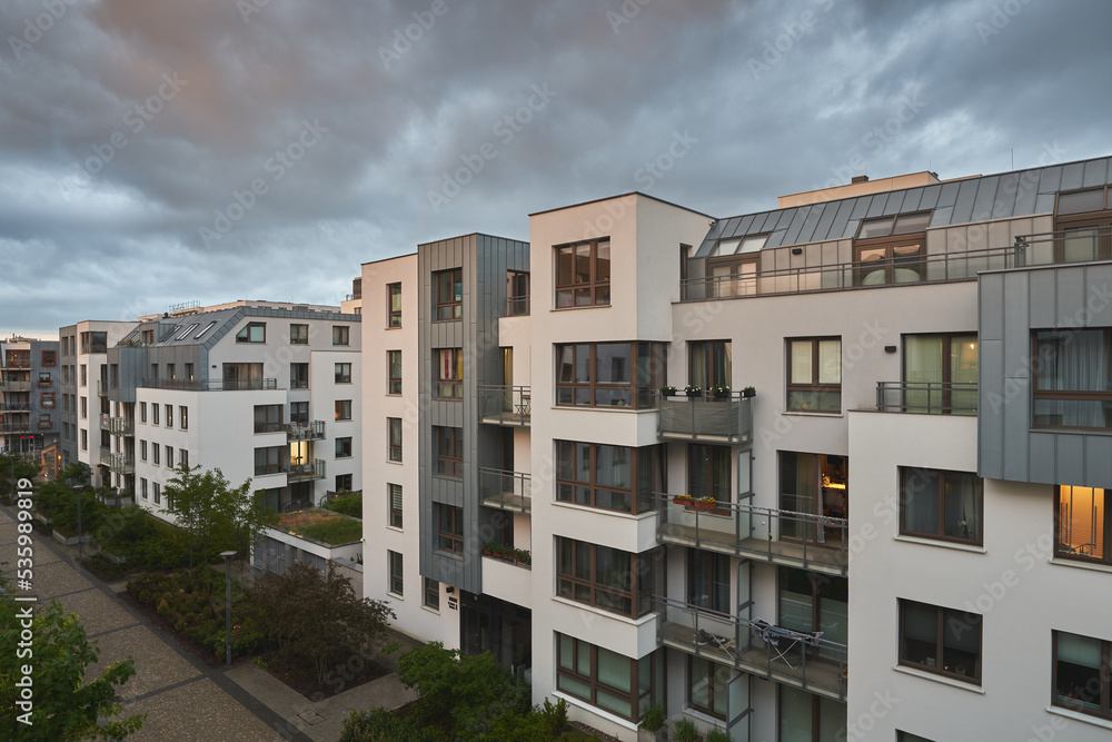 Concept of happy living in a modern house neighborhood and owning real estate. Contemporary resident complex in Europe during summer evenings.