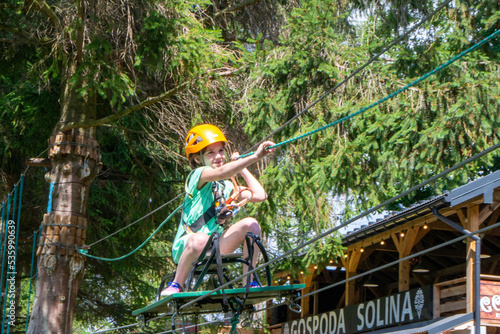 adventure climbing high wire park - people on course in mountain helmet and safety equipment. High quality photo