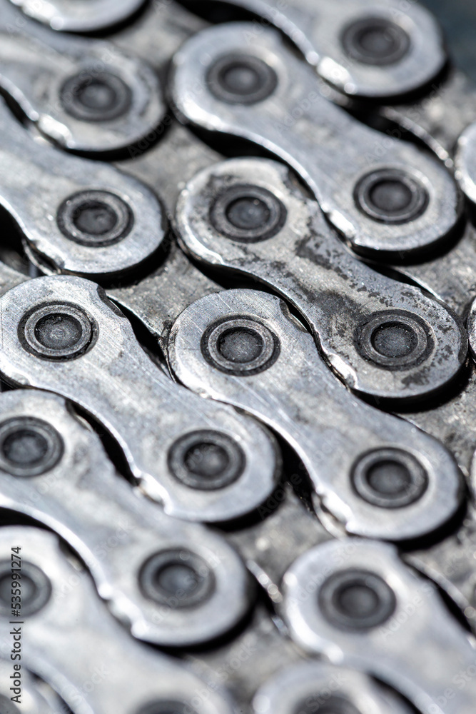 View of Shiny Dirty Greasy Oiled Bicycle Chain As A Part of Metal Bicycle Equipment On Grey Tile Stony Background With Contrast Details View of Shiny Dirty Greasy Oiled Bicycle Chain As A Part of Metal Bicycle Equipment On Grey Tile Stony Background With Contrast Details