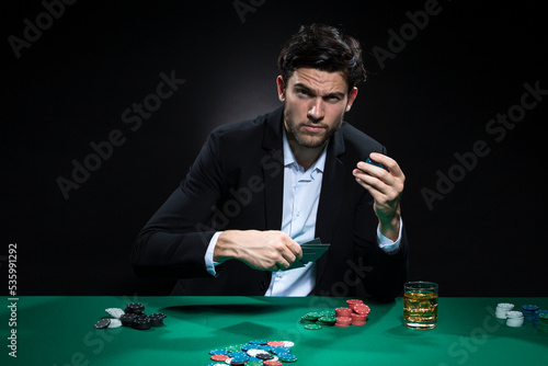 One Emotional Handsome Caucasian Brunet  Pocker Player At Pocker Table With Chips and Cards While Playing