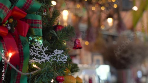Close-up Christmas tree decorated with snowflake and red jingle bells with blurred sparkling fairy background..Festively Christmas and New Year party 2023 , Festival mood Winter holidays concept.
