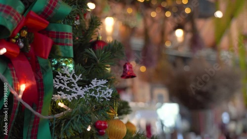 Close-up Christmas tree decorated with snowflake and red jingle bells with blurred sparkling fairy background..Festively Christmas and New Year party 2023 , Festival mood Winter holidays concept.