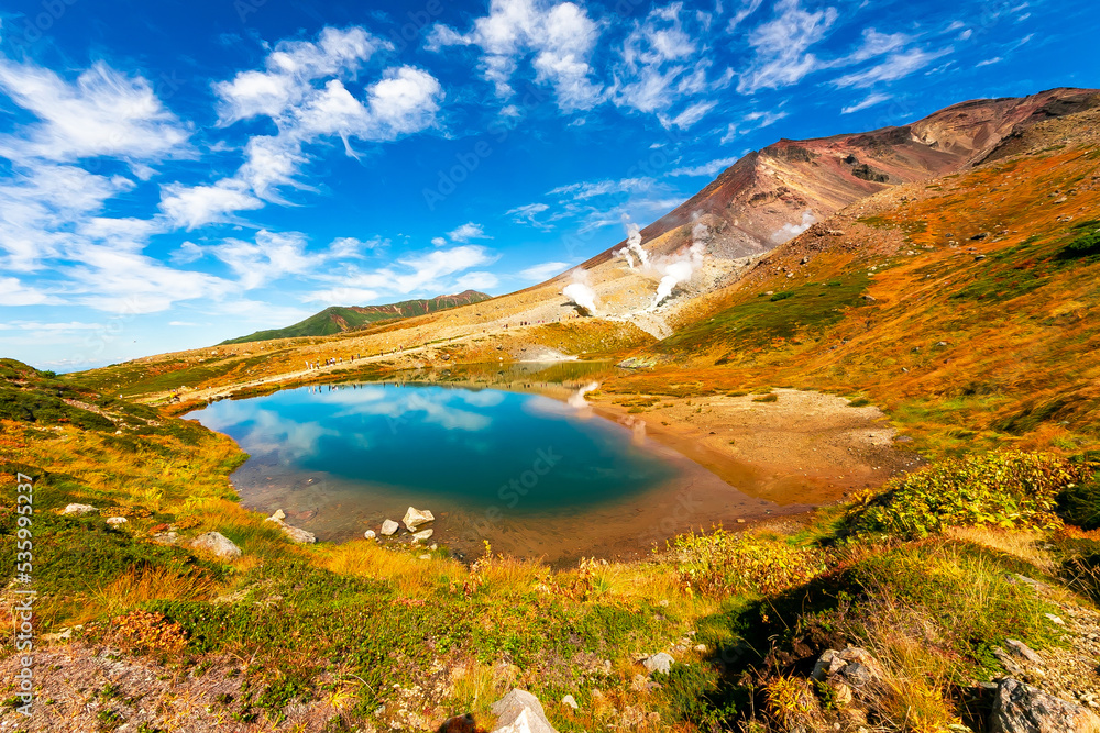 秋の北海道・大雪山の旭岳で見た、池の周辺に広がる紅葉と快晴の青空