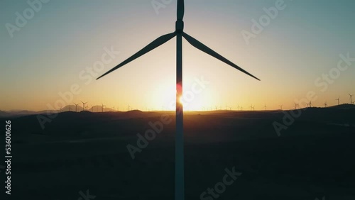 Wind Turbine Blade and Tower Silhouette Spinning at Sunset, Sustainable Renewable Energy Concept photo