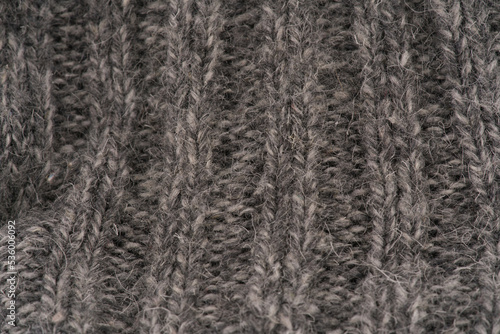 The texture of the wool closeup. Dark gray color. Vertical lines