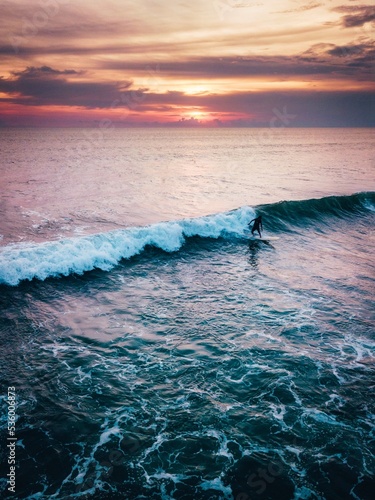 Surfer catching a wave at sunset