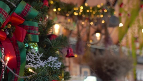 Close-up Christmas tree decorated with snowflake and red jingle bells with blurred sparkling fairy background..Festively Christmas and New Year party 2023 , Festival mood Winter holidays concept.