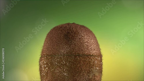 Half Kiwi falling and splashing on white background. Food levitation concept. Slow Motion photo