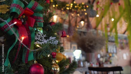 Close-up Christmas tree decorated with snowflake and red jingle bells with blurred sparkling fairy background..Festively Christmas and New Year party 2023 , Festival mood Winter holidays concept.