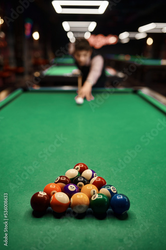 Obraz na plátně Young man aiming with billiards cue