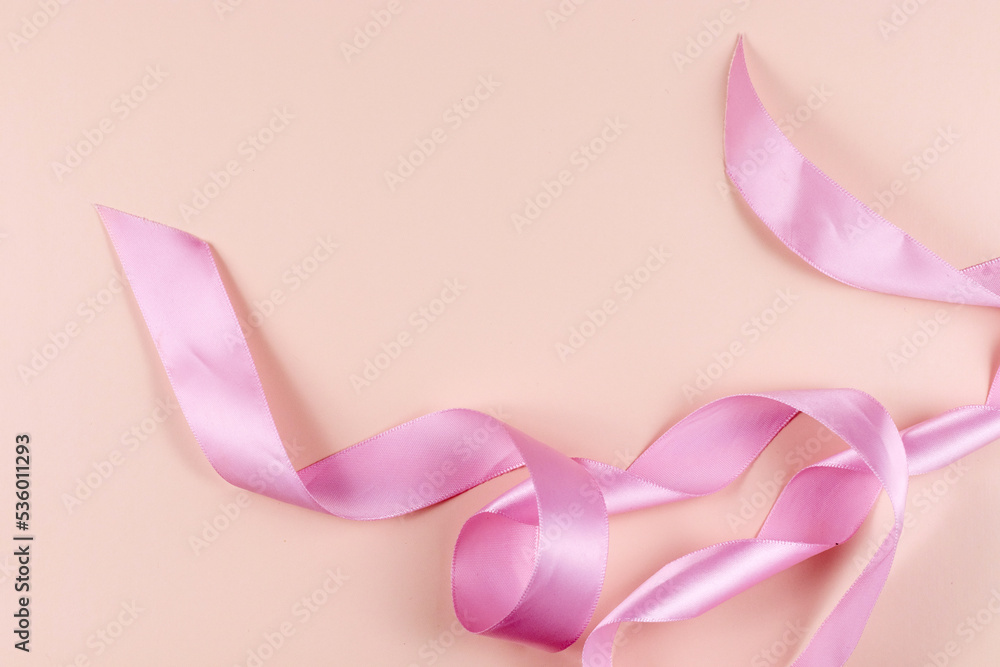 Pink satin ribbon on a pink background. High quality photo