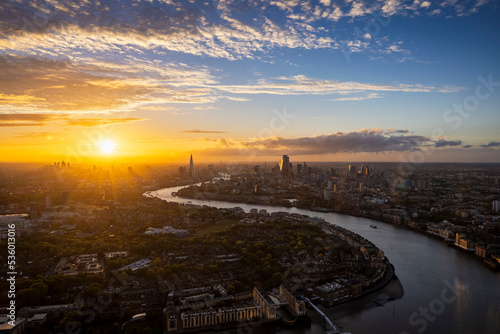 High panoramic sunset view of the urban skyline of London, England, with the river Thames leading into the City disctrict and beyond photo