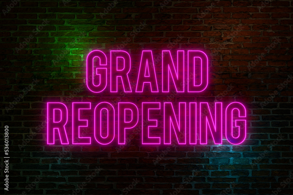 Grand Reopening, neon sign. Brick wall at night with the text Grand Reopening, neon sign. Brick wall at night with the text