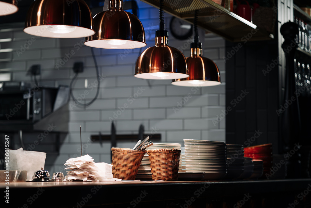 The distribution table in the kitchen of the restaurant. The food warming lamp. Heating system with special infrared lamp to keep food hot before serving them to customers