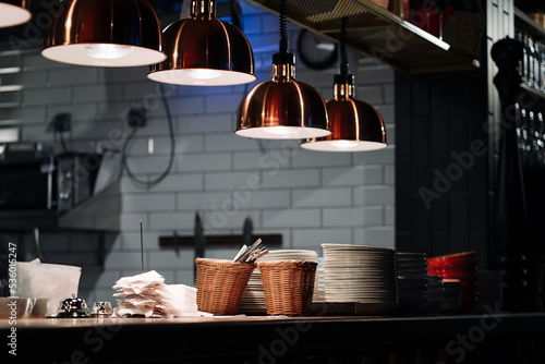 The distribution table in the kitchen of the restaurant. The food warming lamp. Heating system with special infrared lamp to keep food hot before serving them to customers