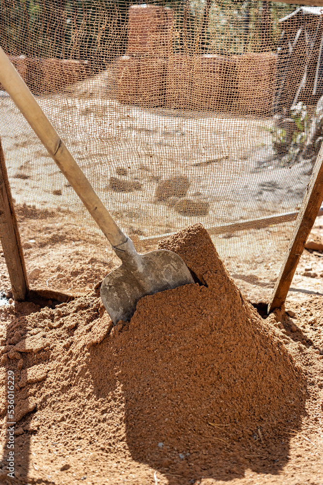 Sifting sand for mortar at the construction site. Purification of sand