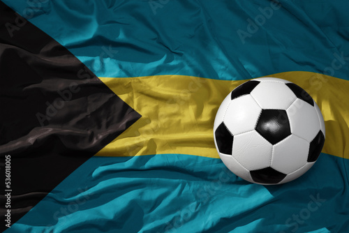 vintage football ball on the waveing national flag of bahamas background. 3D illustration