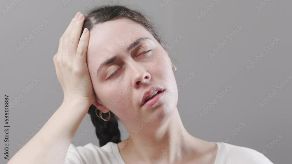 Portrait of young suffering Caucasian woman holds her hands to her forehead. Suffering from headaches and migraines. The concept of stress and psychology. Portrait of young suffering Caucasian woman holds her hands to her forehead. Suffering from headaches and migraines. The concept of stress and psychology.