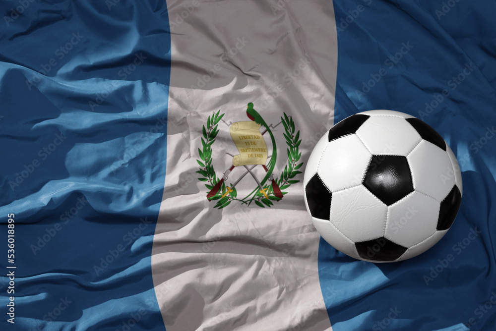 vintage football ball on the waveing national flag of guatemala