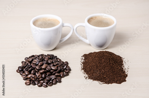 Two coffee cups or mugs with beans and ground coffee on wooden desk or table  I like  love coffee  close-up  coffee making concept