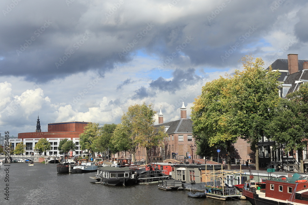 Amsterdam Amstel River View with Buildings, Boats and Autumn Foliage, Netherlands