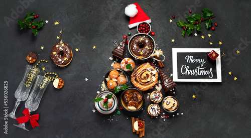 Christmas tree with sweets and cookies decoration on dark background.