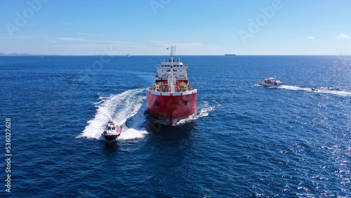 Aerial drone photo of pilot boat and huge crude oil tanker cruising in open ocean deep blue sea