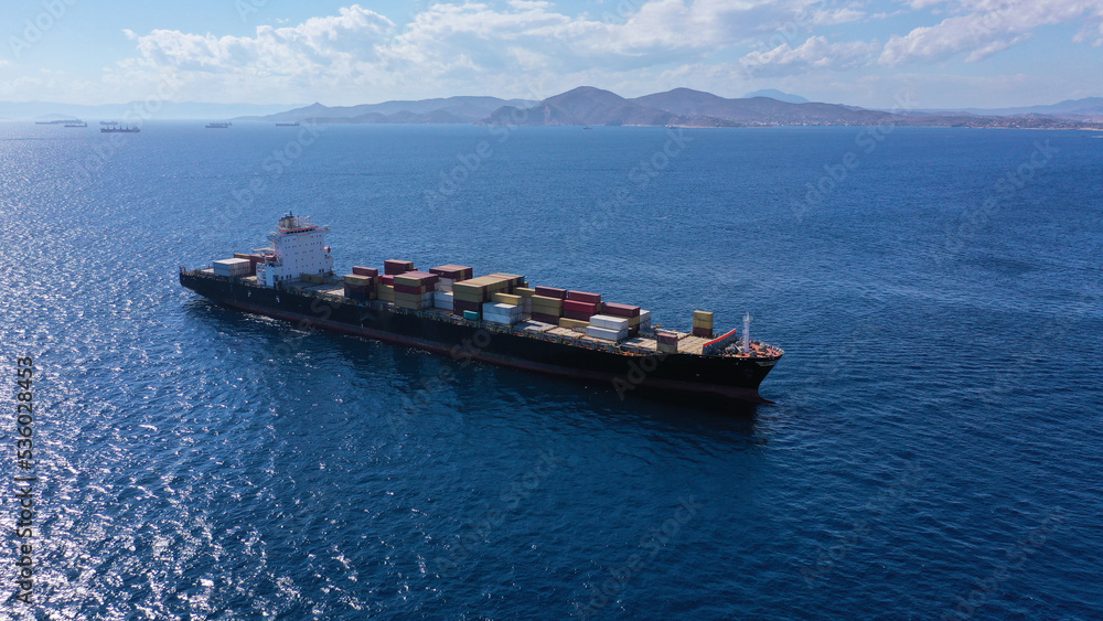 Aerial drone photo of colourful truck size container tanker ship cruising Mediterranean deep blue sea