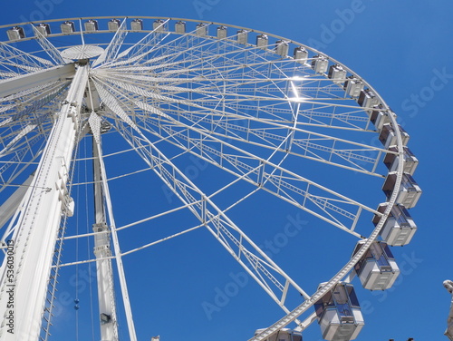 Paris, France: low angle view of the Paris ferris wheel against clear blue sky