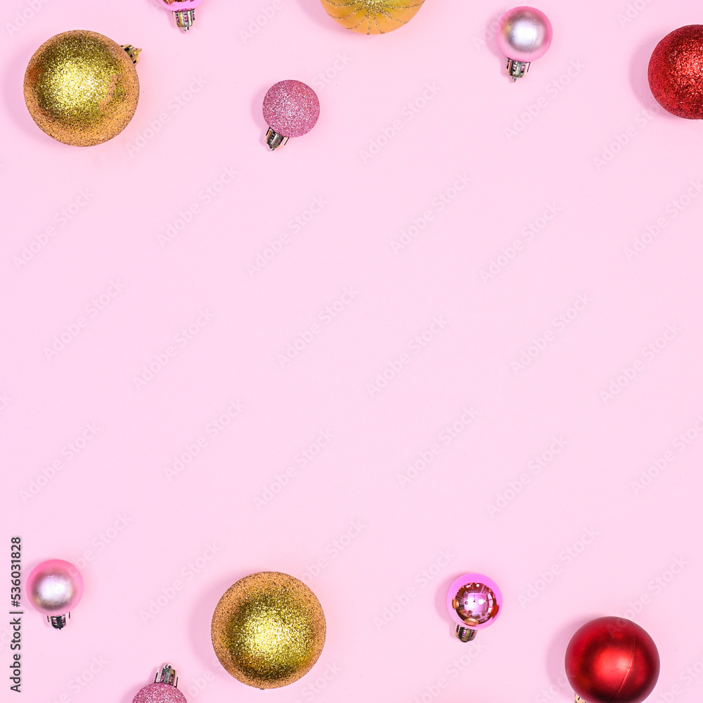 Gold red and pink ornaments Christmas balls on pastel pink copy space background. Flat lay